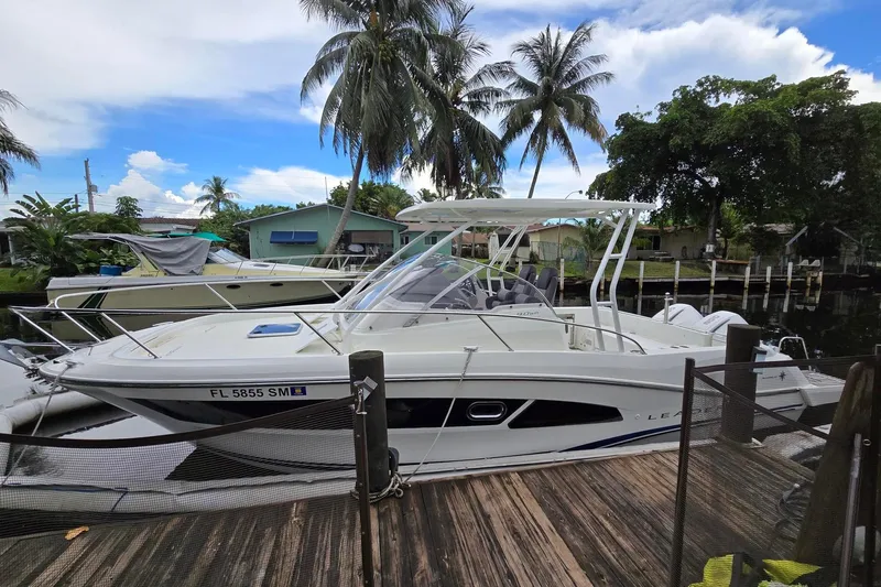  Yacht Photos Pics 2020 Jeanneau Leader 9.0 WA boat docked near palm trees and waterfront homes.