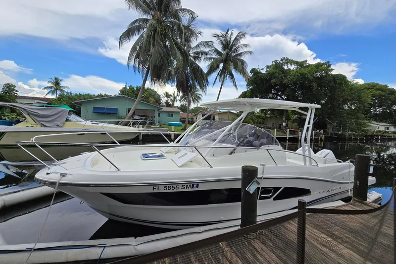  Yacht Photos Pics 2020 Jeanneau Leader 9.0 WA boat docked near palm trees and waterfront homes.