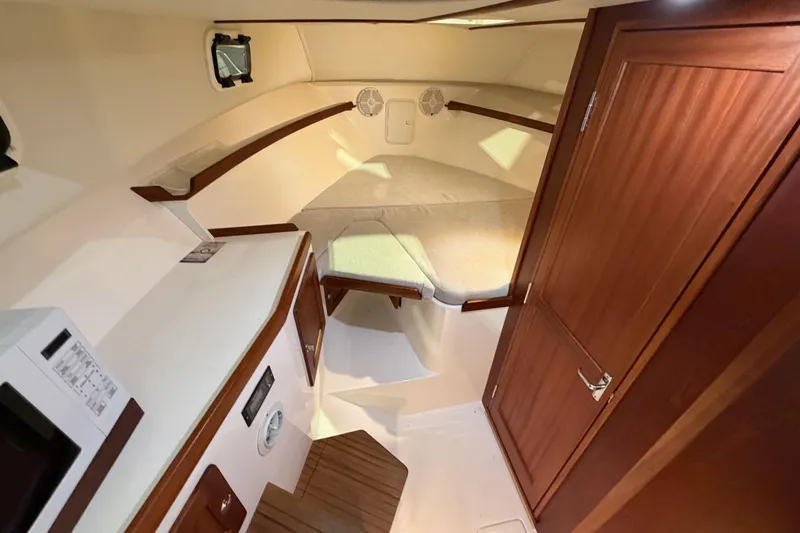 Yacht Photos Pics 2026 NorthCoast 255 Cabin interior with cozy bed and wooden cabinetry.