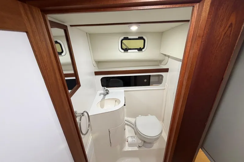  Yacht Photos Pics Compact bathroom in 2026 NorthCoast 255 Cabin boat with sink, toilet, and window.