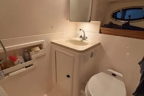 Ocean Cloud Yacht Photos Pics 2001 Tiara Yachts 3500 Open bathroom with sink, toilet, and storage shelves.