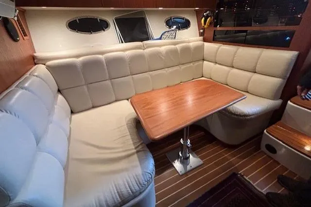 Ocean Cloud Yacht Photos Pics 2001 Tiara Yachts 3500 Open interior with beige seating and wooden table.