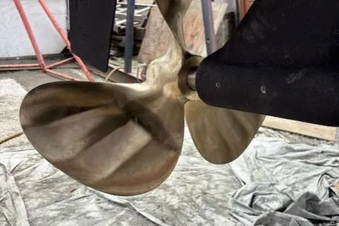 Ocean Cloud Yacht Photos Pics Close-up of a 2001 Tiara Yachts 3500 Open propeller in a workshop setting.