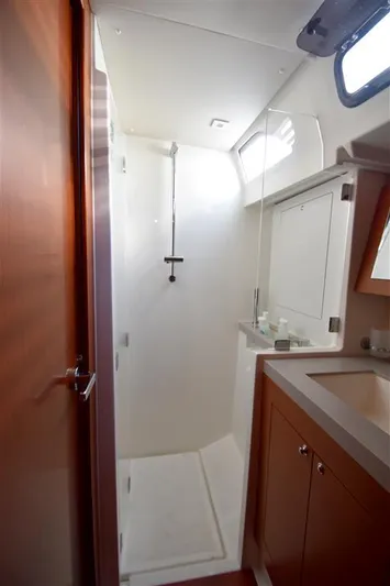  Yacht Photos Pics 2019 Beneteau 51.1 yacht bathroom with shower, sink, and wooden cabinetry.