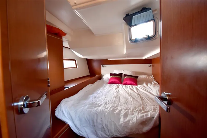  Yacht Photos Pics Luxurious cabin interior of 2019 Beneteau 51.1 yacht with cozy bedding and wooden finish.