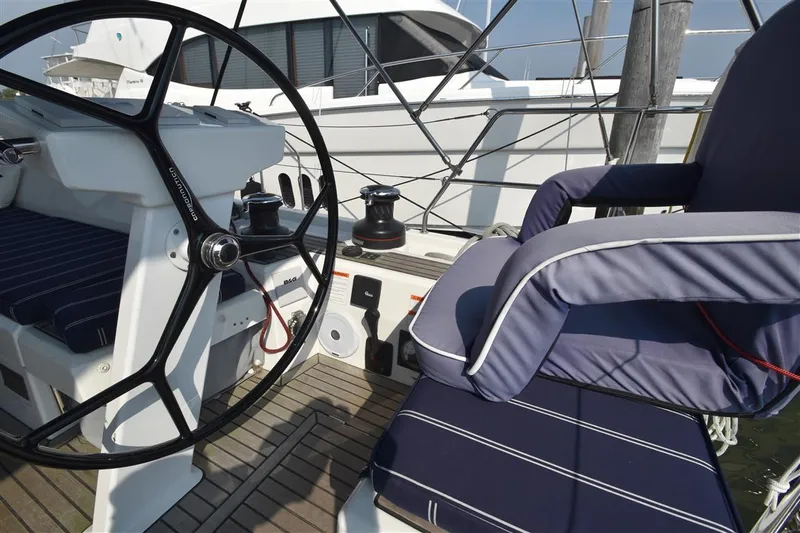  Yacht Photos Pics 2019 Beneteau 51.1 yacht cockpit with steering wheel and cushioned seating.