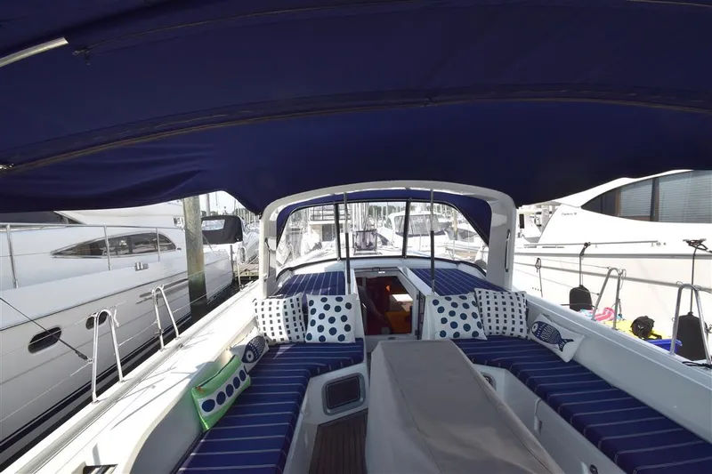  Yacht Photos Pics 2019 Beneteau 51.1 yacht cockpit with blue canopy and striped seating.