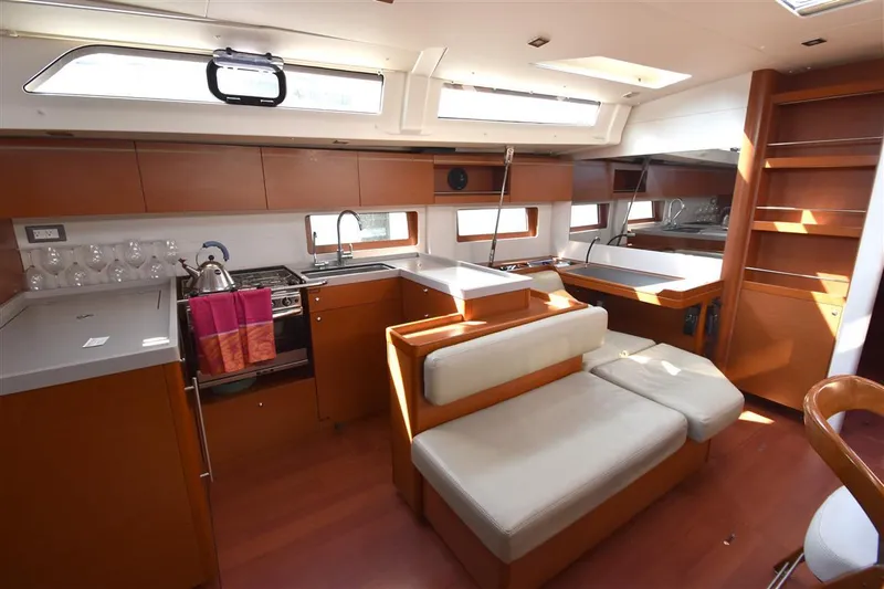  Yacht Photos Pics Modern interior of 2019 Beneteau 51.1 yacht with kitchen and seating area.