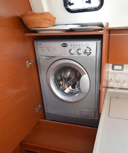  Yacht Photos Pics Washing machine in 2019 Beneteau 51.1 yacht interior, wooden cabinetry, compact design.
