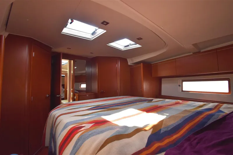  Yacht Photos Pics Luxurious interior of 2019 Beneteau 51.1 yacht with skylights and colorful bedding.