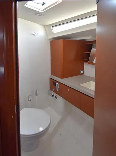  Yacht Photos Pics 2019 Beneteau 51.1 yacht bathroom with modern fixtures and wood cabinetry.