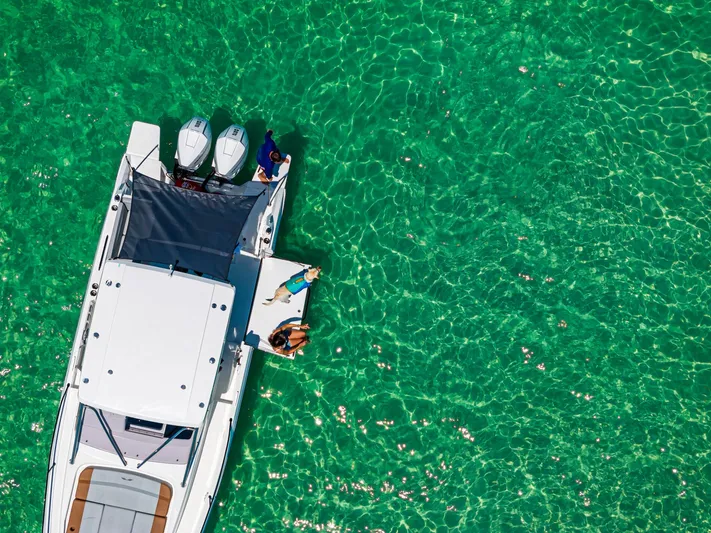  Yacht Photos Pics 2025 Beneteau Flyer 9 SUNdeck on clear turquoise water, aerial view.