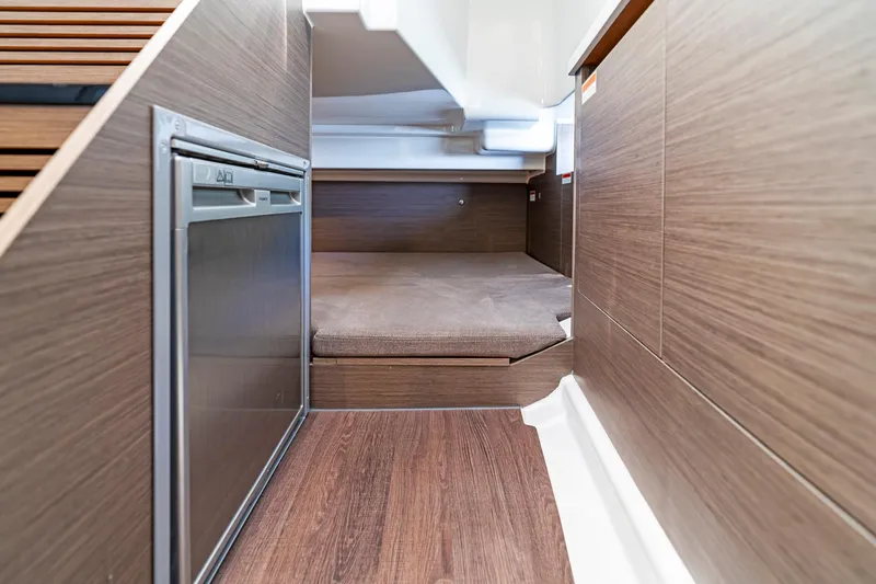  Yacht Photos Pics 2025 Beneteau Flyer 9 SUNdeck interior cabin with wood finish and compact fridge.