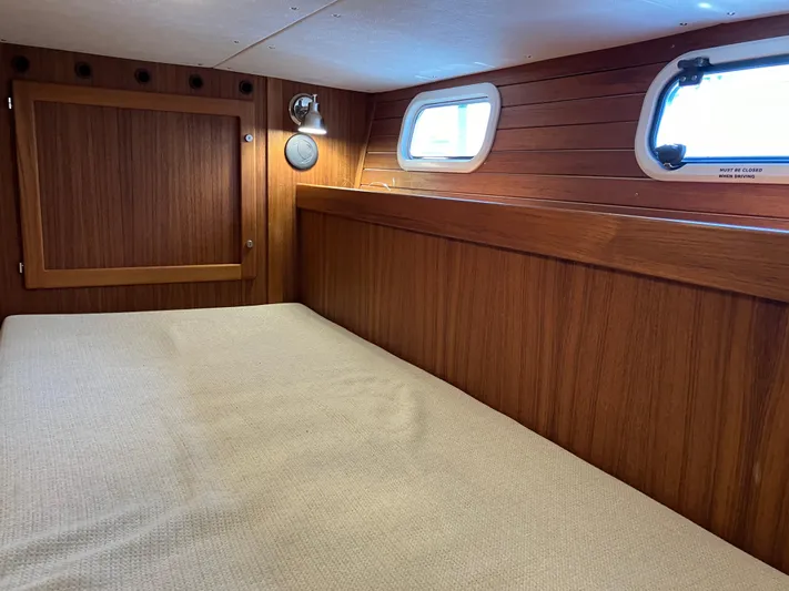  Yacht Photos Pics Cozy cabin interior of 2016 Targa 44 CFC with wooden paneling and porthole windows.