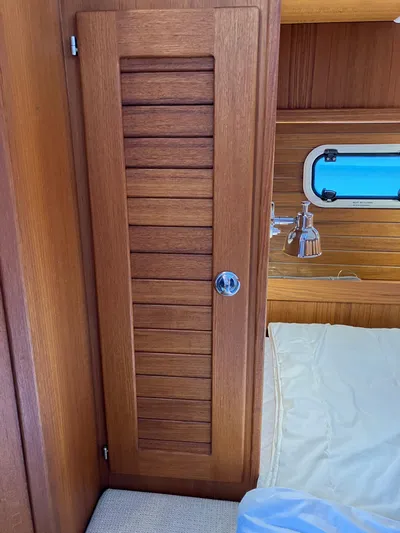  Yacht Photos Pics Wooden interior of 2016 Targa 44 CFC boat with louvered door and porthole.