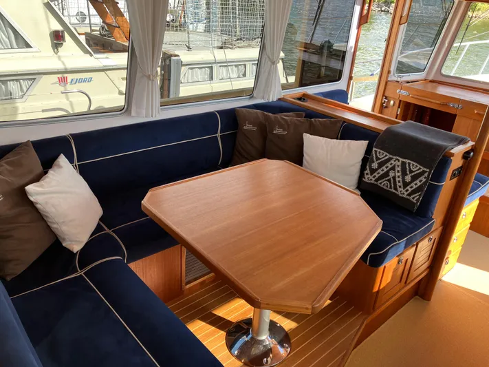  Yacht Photos Pics Cozy interior of 2016 Targa 44 CFC yacht with blue seating and wooden table.