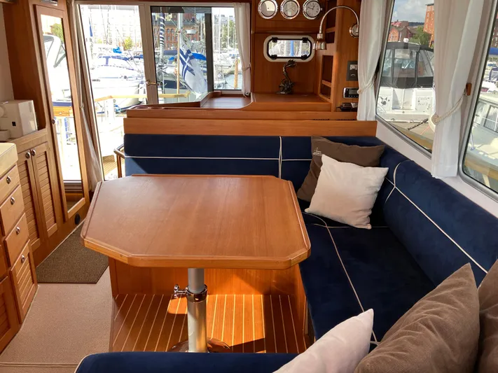  Yacht Photos Pics Interior of 2016 Targa 44 CFC yacht with wooden table and blue seating.