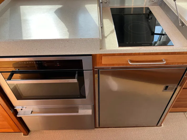  Yacht Photos Pics Modern kitchen in 2016 Targa 44 CFC yacht with stove, oven, and fridge.