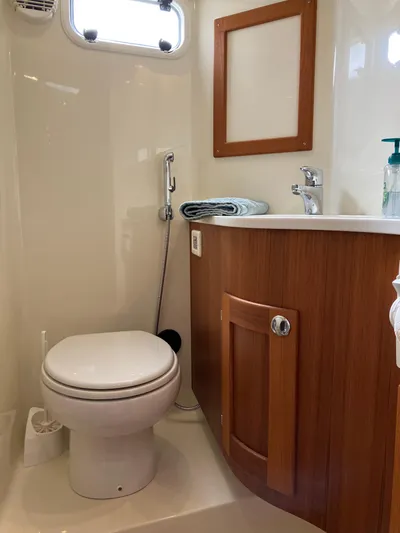  Yacht Photos Pics 2016 Targa 44 CFC boat bathroom with wooden cabinetry and modern fixtures.