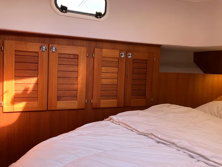  Yacht Photos Pics Cozy cabin interior of 2016 Targa 44 CFC with wooden cabinets and bedding.