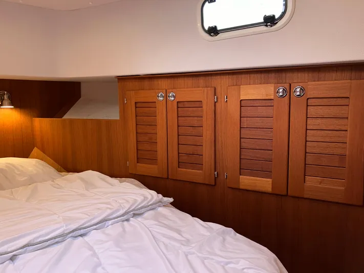  Yacht Photos Pics Cozy cabin interior of 2016 Targa 44 CFC with wooden cabinets and bedding.