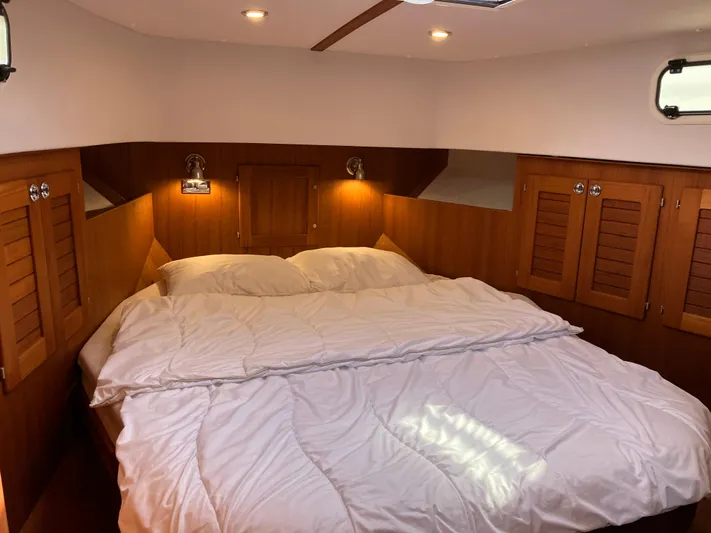  Yacht Photos Pics Cozy cabin interior of 2016 Targa 44 CFC yacht with wooden finish and comfortable bedding.
