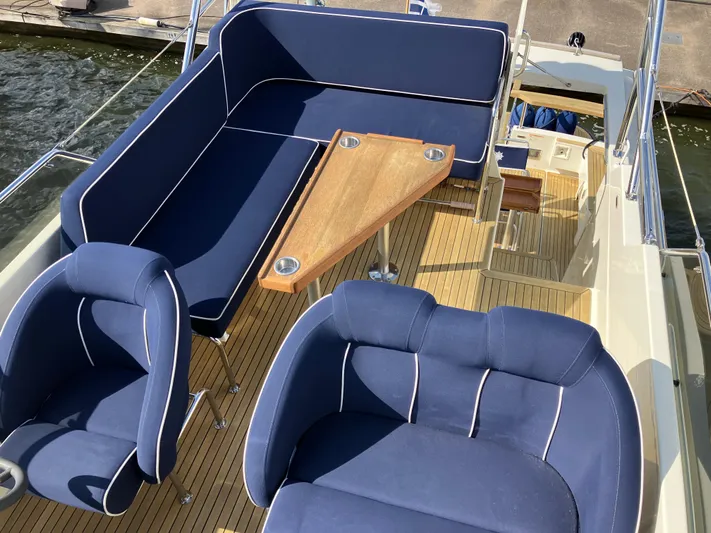  Yacht Photos Pics Luxury seating on 2016 Targa 44 CFC yacht with blue cushions and wooden deck.