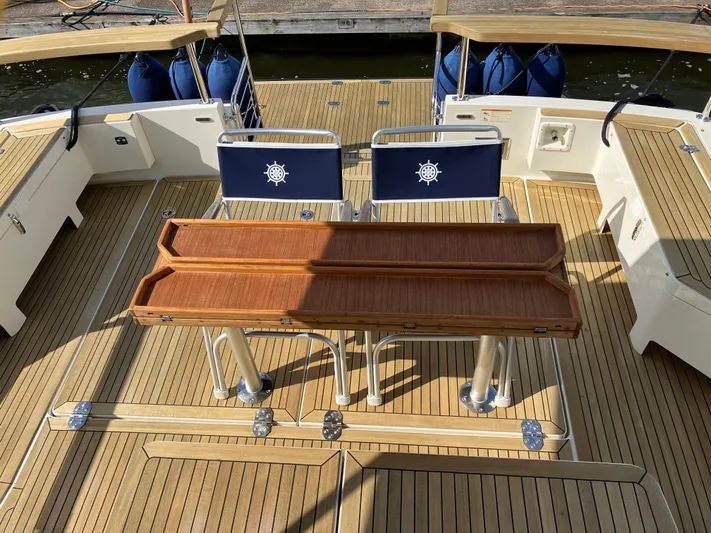  Yacht Photos Pics Targa 44 CFC 2016 boat deck with wooden table and nautical-themed chairs.