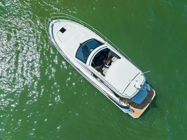 In Stock Yacht Photos Pics 2023 Beneteau Gran Turismo 41 yacht cruising on green water, aerial view.