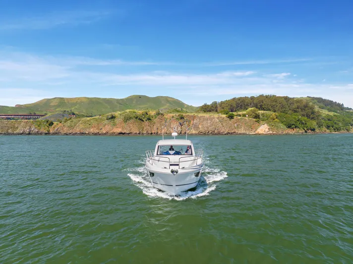 In Stock Yacht Photos Pics 2023 Beneteau Gran Turismo 41 cruising on a scenic lake with lush hills in the background.