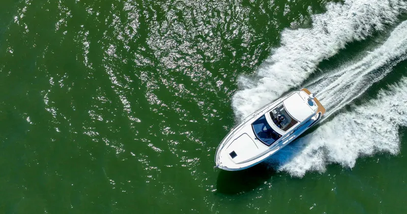 In Stock Yacht Photos Pics 2023 Beneteau Gran Turismo 41 cruising on green water, aerial view.