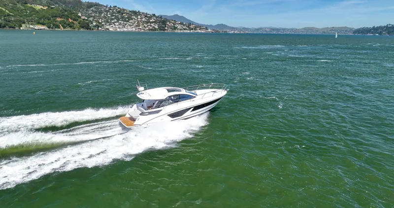 In Stock Yacht Photos Pics 2023 Beneteau Gran Turismo 41 cruising on open water, scenic coastal backdrop.