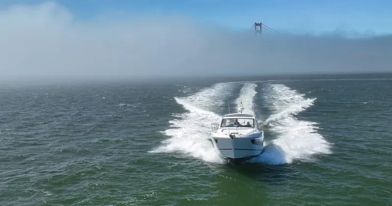 In Stock Yacht Photos Pics 2023 Beneteau Gran Turismo 41 cruising on open water with bridge in background.