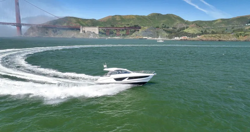 In Stock Yacht Photos Pics 2023 Beneteau Gran Turismo 41 cruising near a bridge on a sunny day.