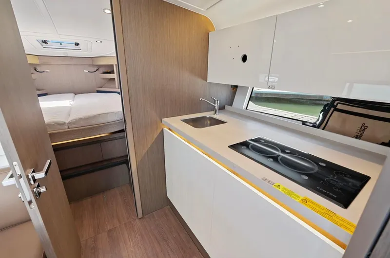 In Stock Yacht Photos Pics 2023 Beneteau Gran Turismo 41 interior with modern kitchenette and cozy bedroom.