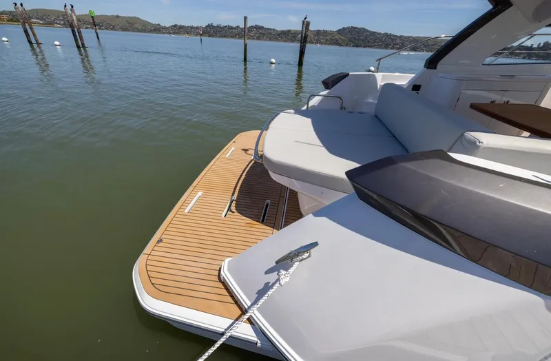 In Stock Yacht Photos Pics 2023 Beneteau Gran Turismo 41 yacht with teak swim platform on calm water.