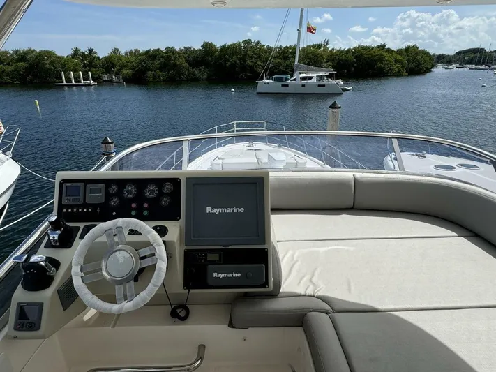  Yacht Photos Pics 2012 Azimut 64 yacht helm with Raymarine navigation, docked near lush greenery and calm waters.