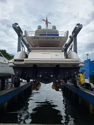  Yacht Photos Pics 2012 Azimut 64 yacht named "Odyssey" in dry dock, rear view with cloudy sky.