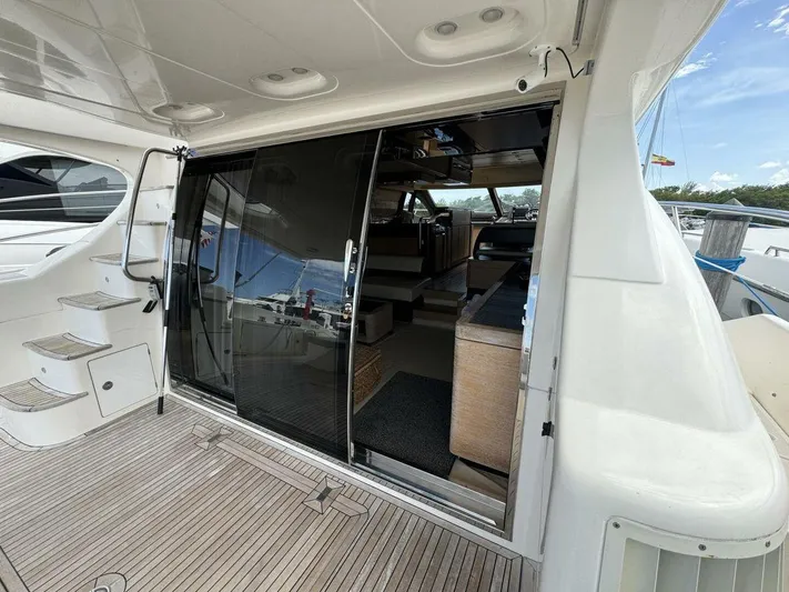  Yacht Photos Pics 2012 Azimut 64 yacht interior view with sliding glass doors and wooden deck.