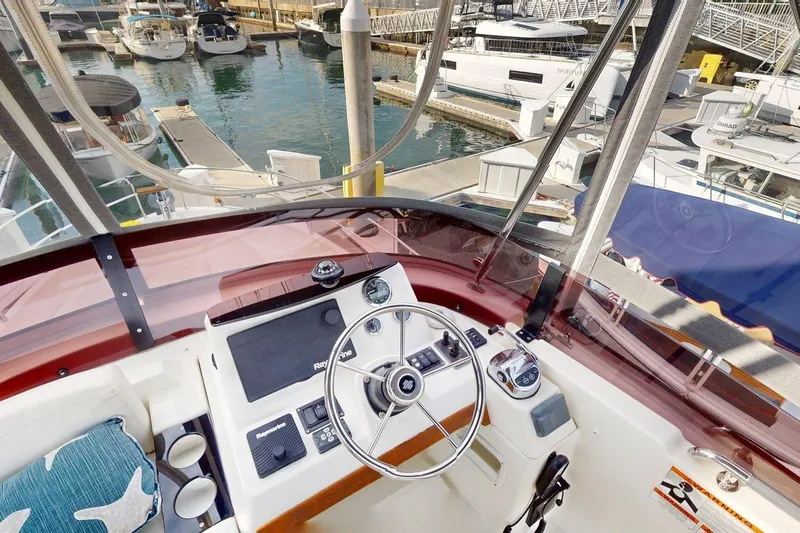 Vitamin Sea Yacht Photos Pics Cockpit view of 2021 Beneteau Swift Trawler 35 at marina, showcasing helm and controls.