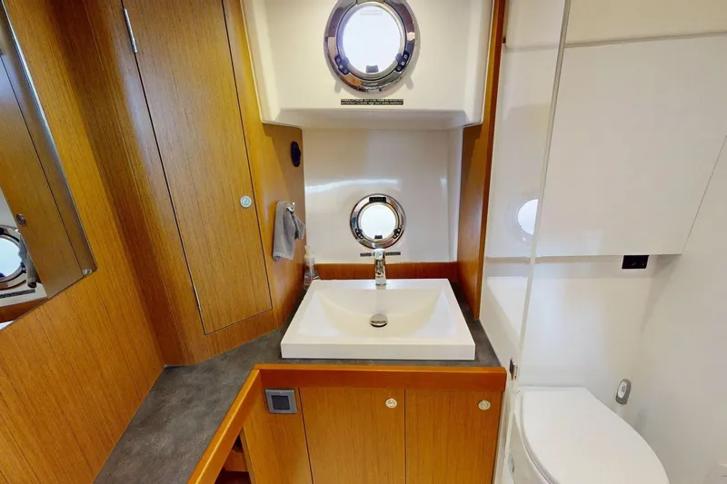 Vitamin Sea Yacht Photos Pics Bathroom interior of 2021 Beneteau Swift Trawler 35 with sink and porthole window.