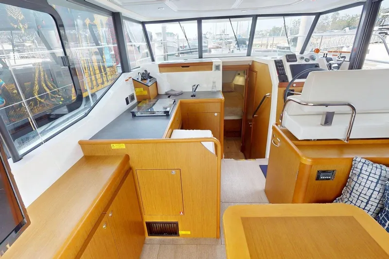 Vitamin Sea Yacht Photos Pics Interior of 2021 Beneteau Swift Trawler 35, featuring modern wood cabinetry and helm station.