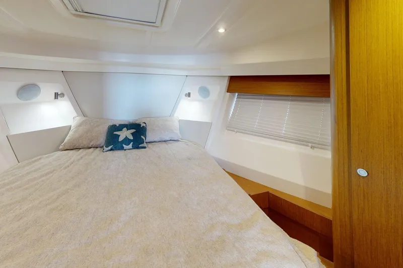 Vitamin Sea Yacht Photos Pics Cozy bedroom interior of 2021 Beneteau Swift Trawler 35 with starfish-themed pillow.