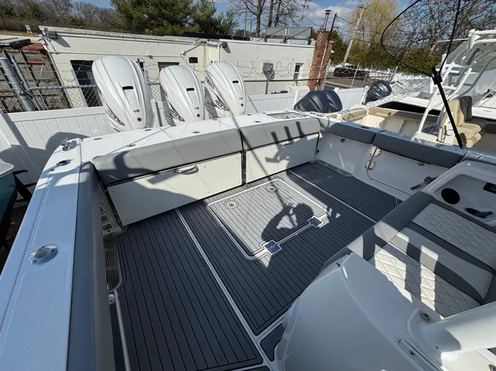  Yacht Photos Pics 2022 Everglades 395cc boat deck with triple outboard engines, featuring spacious seating and modern design.