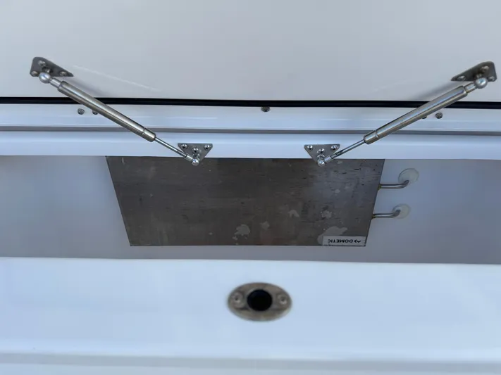  Yacht Photos Pics Open storage compartment of 2022 Everglades 395cc boat with metal hinges.