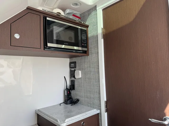  Yacht Photos Pics Compact kitchen area in a 2022 Everglades 395cc, featuring a microwave and countertop.