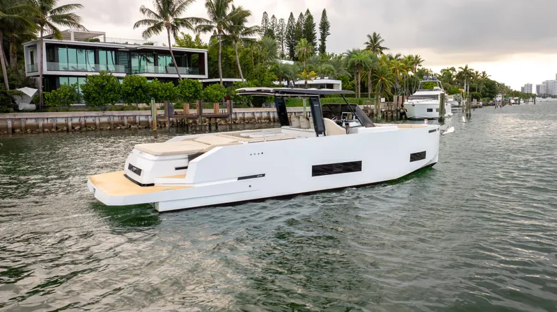  Yacht Photos Pics 2025 De Antonio Yachts D42 Open cruising near luxury waterfront homes.