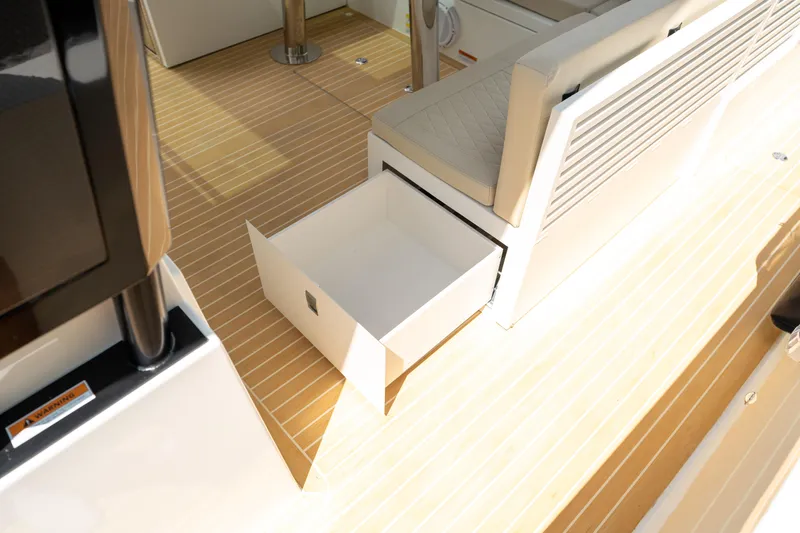  Yacht Photos Pics 2025 De Antonio Yachts D42 Open interior with open storage drawer on wooden deck.