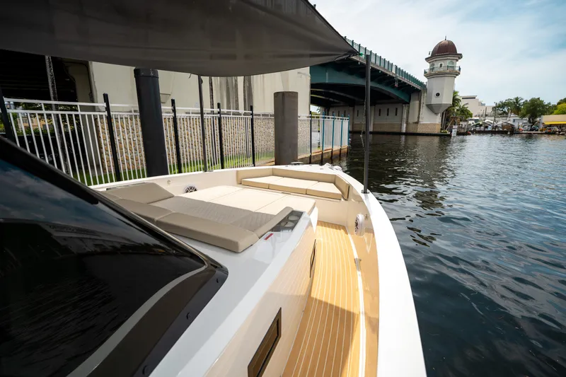  Yacht Photos Pics 2025 De Antonio Yachts D42 Open docked by a scenic waterfront bridge.