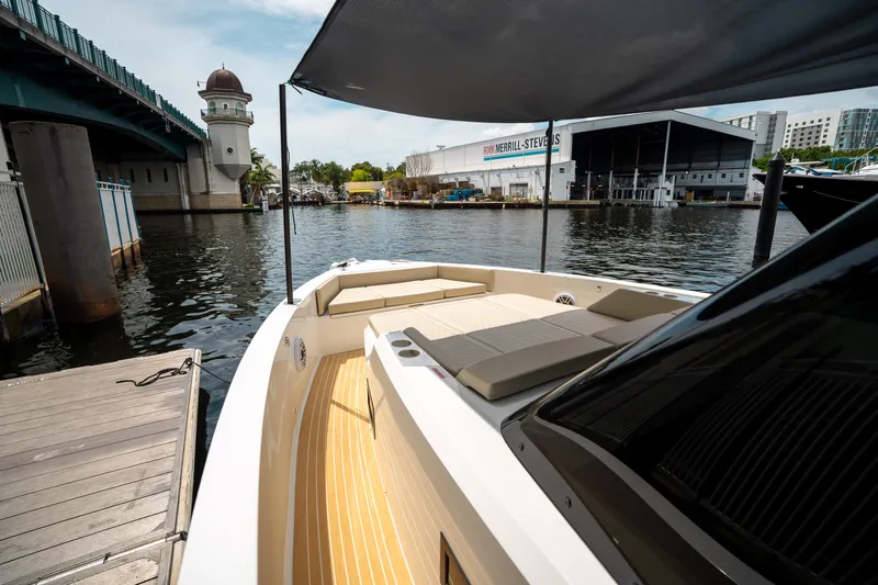  Yacht Photos Pics 2025 De Antonio Yachts D42 Open docked near a bridge, showcasing sleek design and spacious deck.